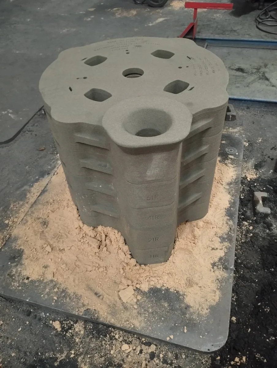 Stacked 3D-printed sand mould package on a foundry floor before assembly