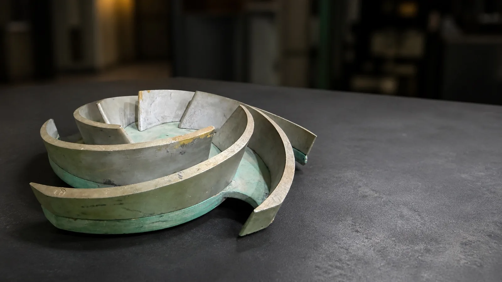 Segmented reusable pattern sections with curved shroud profiles resting on a workshop table